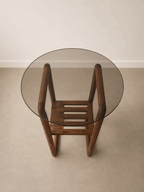 Table d’appoint ronde en bois avec plateau en verre fumé et étagère à lattes.
