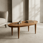 Table basse en bois au plateau ovale et pieds galbés, avec objets décoratifs dessus.