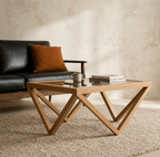 Table basse en bois clair avec plateau en verre et pieds croisés en diagonale