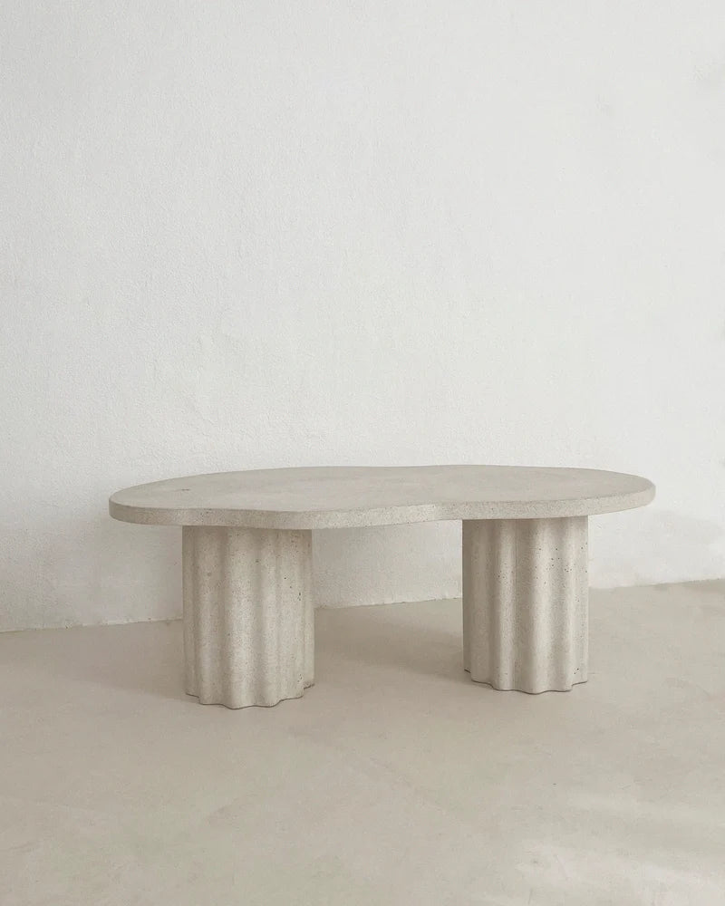 Table basse HESTIA à plateau rond clair et pieds cylindriques cannelés, vue de face.