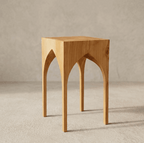 Table d’appoint St. André en bois clair, vue face avec découpes en arcs sous le plateau.