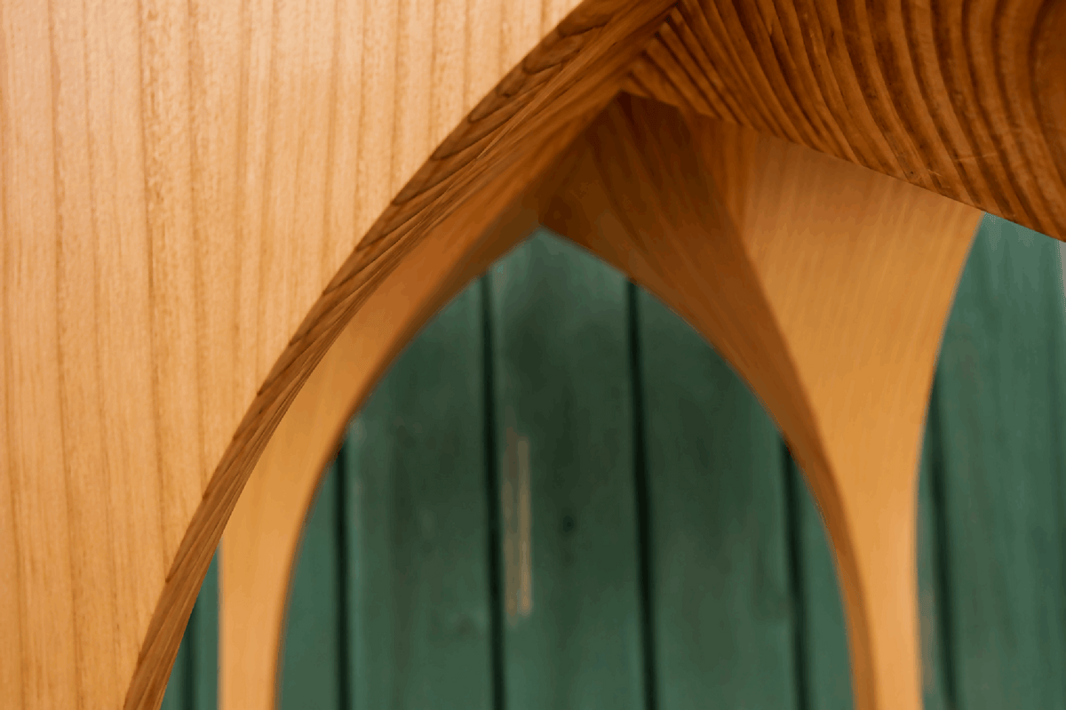 Table d’appoint St. André en bois clair, détail de l’arche et du chant du plateau
