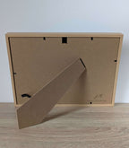 Dos du tableau encadré en bois clair avec accroche et étiquette de fabricant.