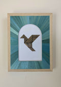 Tableau marqueterie en paille : oiseau géométrique brun et turquoise dans un cadre beige.