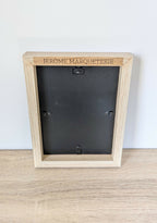 Dos de tableau marqueterie : cadre beige avec étiquette « JEROME MARQUETERIE » et attaches.