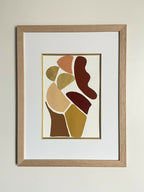 Tableau encadré d’art abstrait, silhouettes stylisées brunes et dorées sur fond clair.