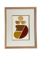 Tableau abstrait encadré, motifs géométriques dorés et rouges dans cadre en bois clair.