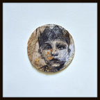 Tableau original encadré : portrait circulaire en encre noire et beige, touches orange.