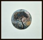 Tableau rond de l’arbre, dans un cadre foncé, tons bleus et bruns.