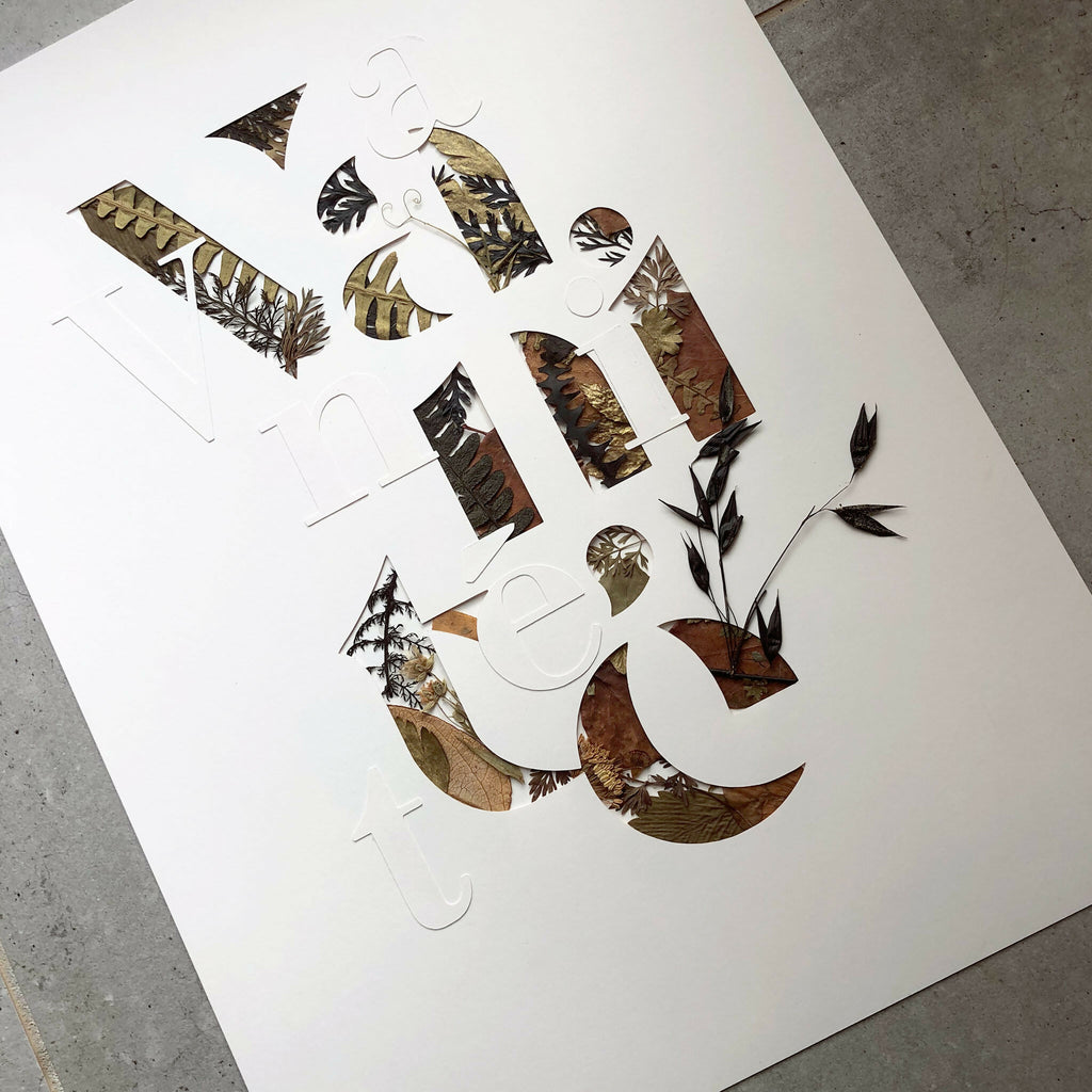 Tableau A3, vue en diagonale : collage végétal découpé en lettres, sur fond clair
