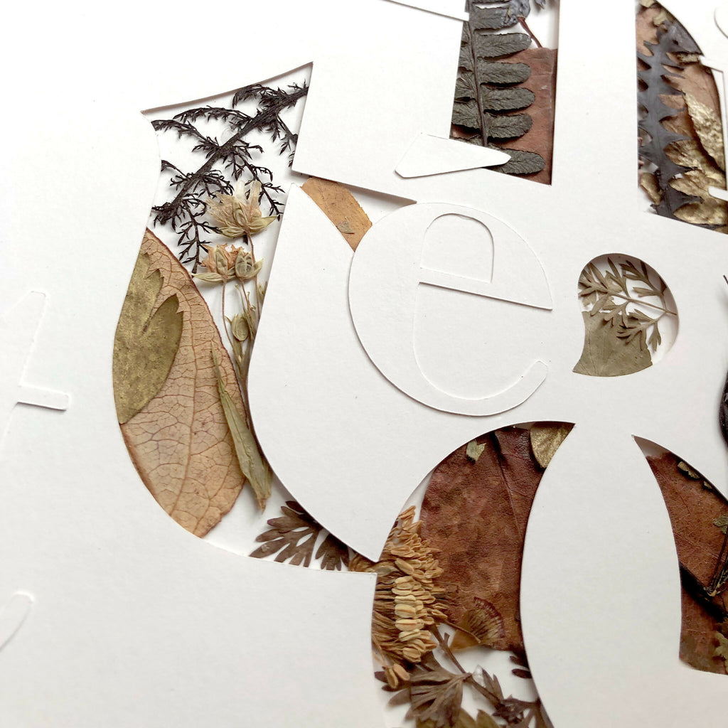 Tableau A3 en collage de plantes séchées : lettres aux formes courbes, fond clair