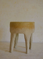 Tabouret en céramique beige texturé, plateau arrondi et pieds évasés