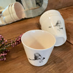 Tasses à ristretto blanches avec motif d’oiseau noir, vues rapprochées et une tasse au premier plan