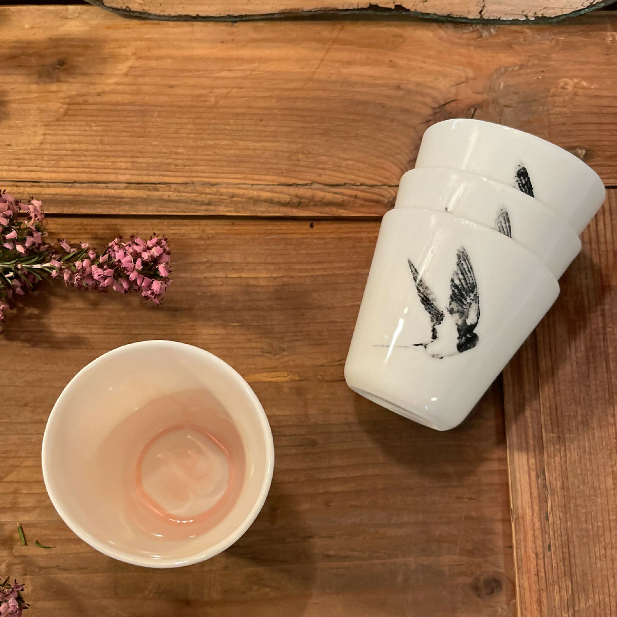 Tasse à ristretto blanche en céramique avec motif d’oiseau noir, vue de dessus partielle