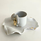Tasse blanche avec soucoupe homard et éclats dorés sur les contours.