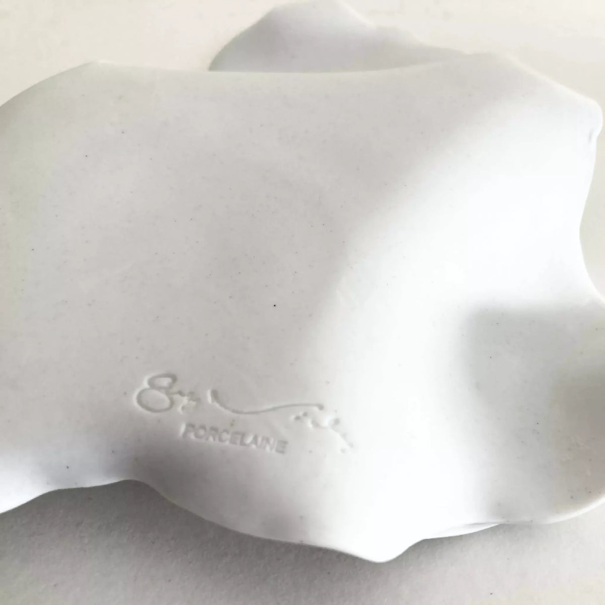 Dessous de la soucoupe en porcelaine blanche, marquage « PORCELAINE ».