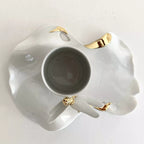 Tasse blanche sur soucoupe en porcelaine avec décor libellule doré