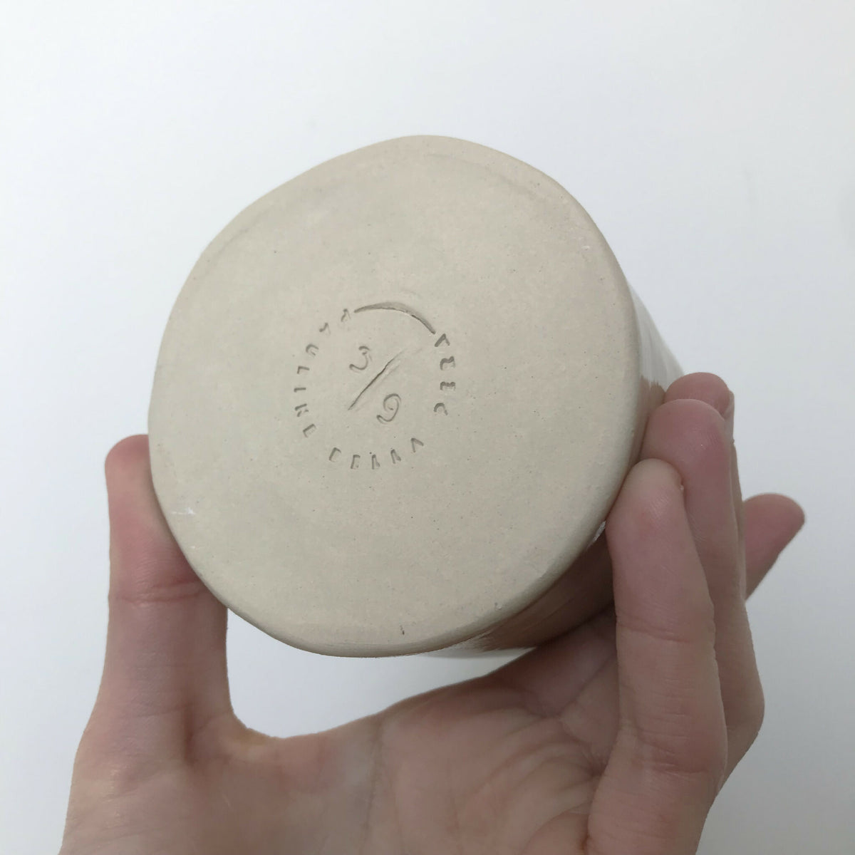 Tasse en céramique beige, vue du dessous avec marquage