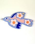 Oiseau en bois bleu clair avec fleurs orange et étoiles jaunes