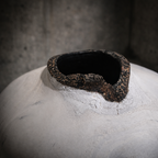 Vase céramique blanche : gros plan sur l’ouverture noire bordée de résidu brun.