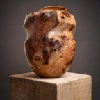 Vase en bois sculpté couleur miel, taches sombres et veinures, bord légèrement évasé.