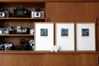 Triptyque de photos architecturales en trois cadres blancs, paysage bleu-gris