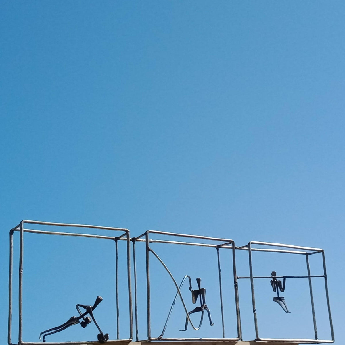 Tryptique décoratif en métal, vue en contre-plongée, silhouettes d’exercices