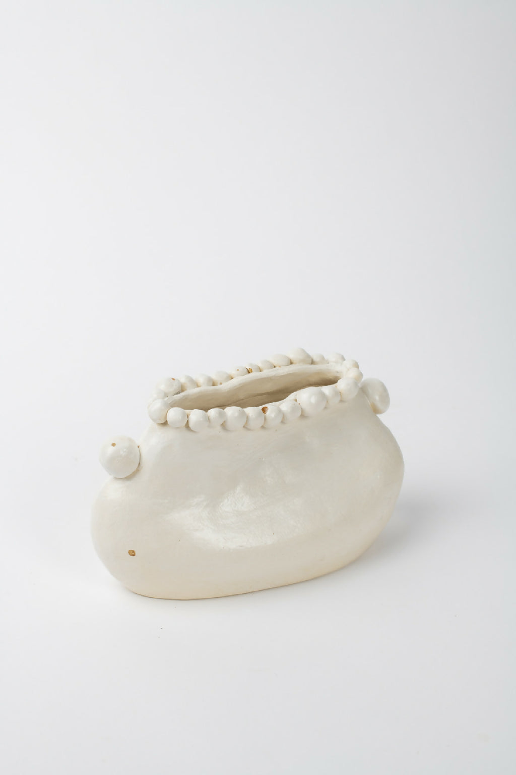 Vase en céramique blanche, forme arrondie avec rangée de perles sur le bord