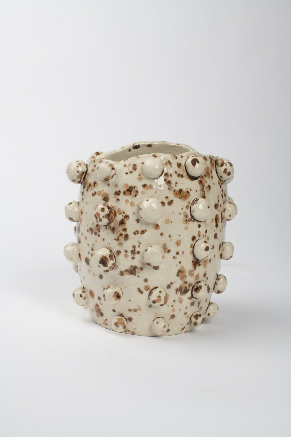 Vase cylindrique en céramique beige, motif taches brunes, bord côtelé et perles