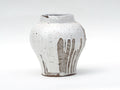 Petit vase en céramique blanc, texture mouchetée et motifs verticaux gris-brun.
