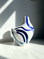 Vase buste organique blanc avec motifs bleus, forme arrondie et col évasé