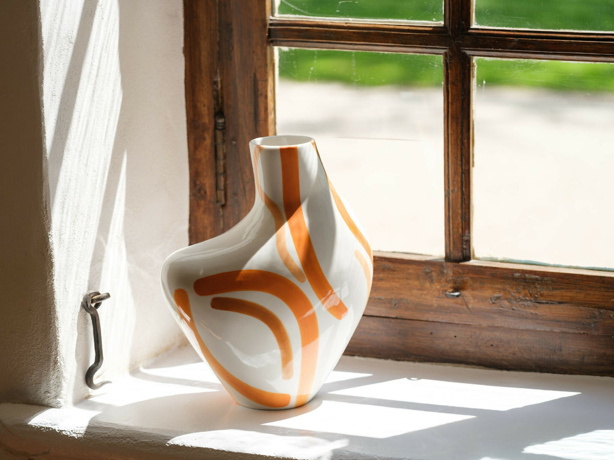 Vase buste organique blanc, motifs orangés stylisés sur surface lisse