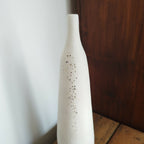 Vase en céramique blanc, col étroit, décor de points brun-noir et doré.