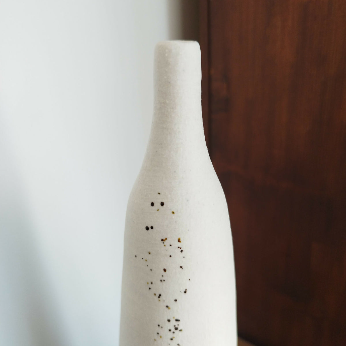 Vase en céramique blanc, panse avec motif de points brun-noir et doré.