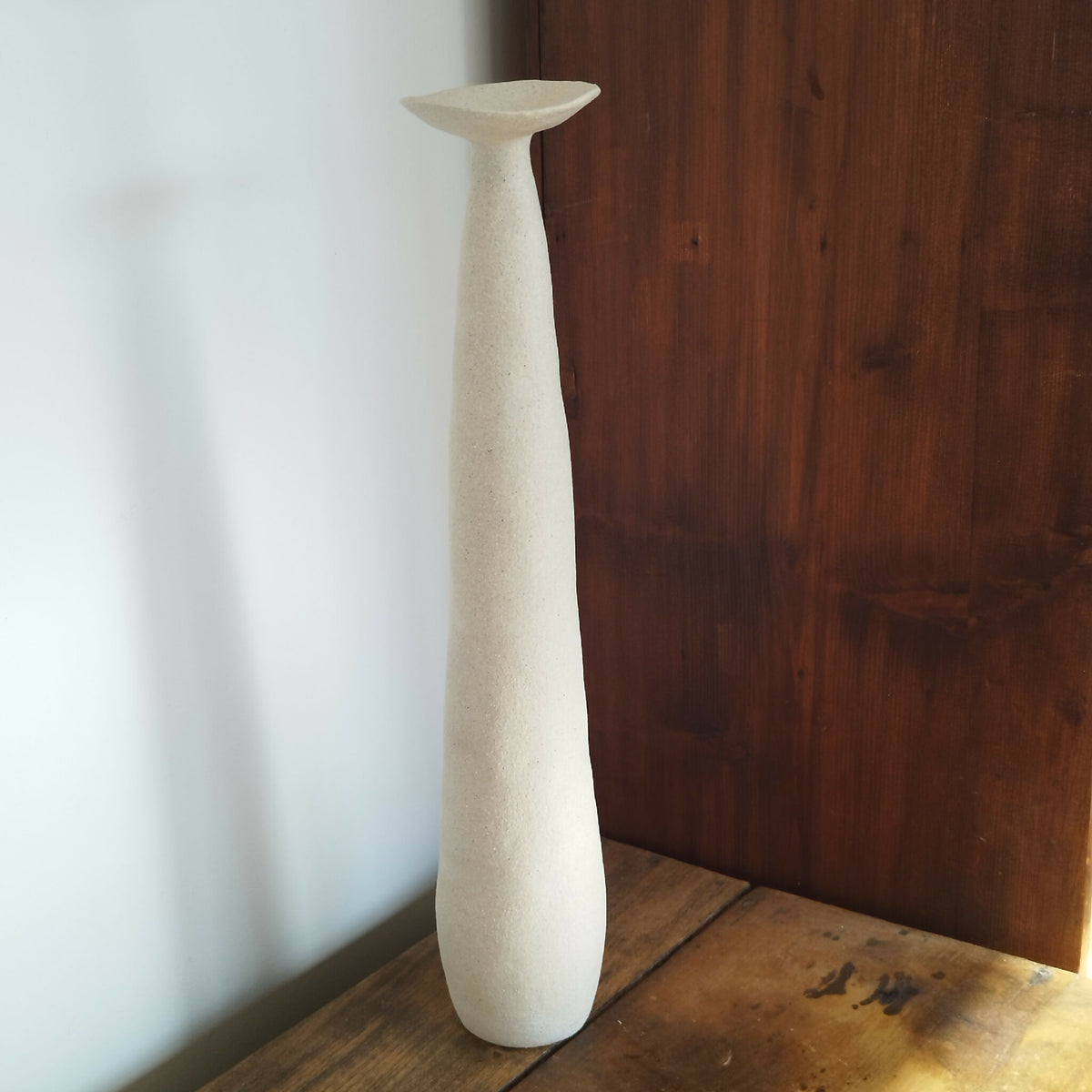 Vase en céramique Élan beige clair, haut évasé et base fine.