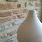 Vase en céramique blanc cassé, gros plan du col et de la texture mate