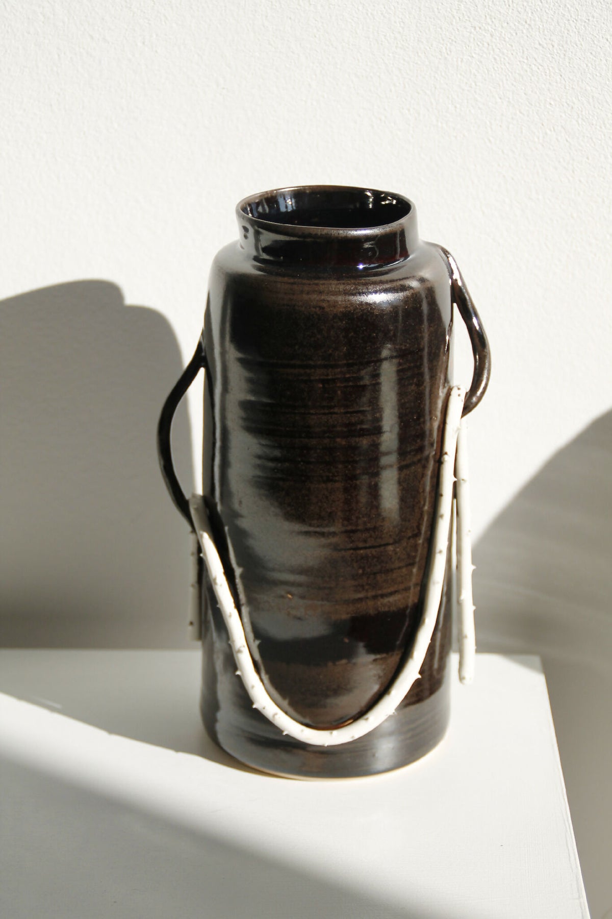 Vase en céramique brun foncé avec deux anses, ouverture large, brillant