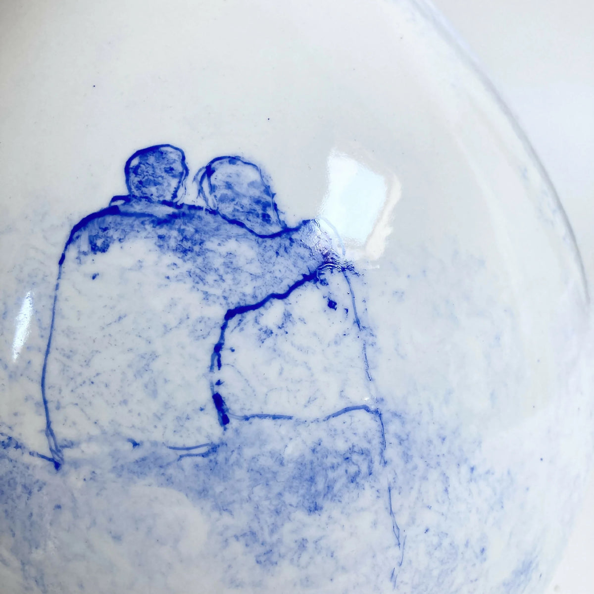 Vase blanc avec illustration en bleu d’un couple, vue rapprochée