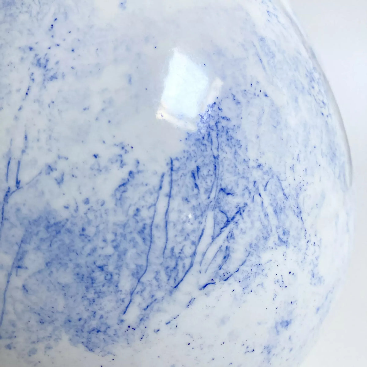 Vase blanc avec traces bleues artistiques sur la surface