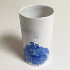 Vase en céramique blanc avec couple méditant en bleu sur la partie basse.