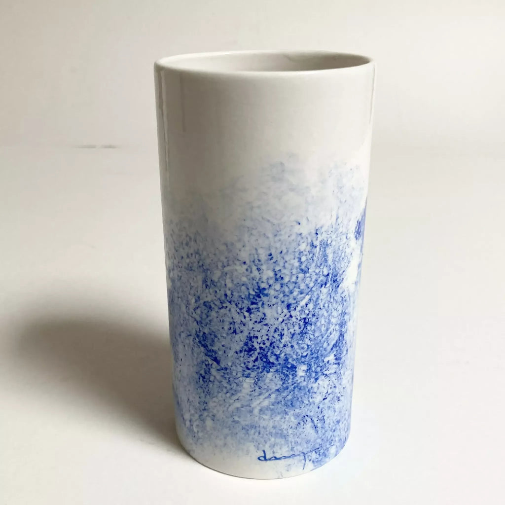Vase cylindrique blanc au fond bleu moucheté, base avec signature bleue