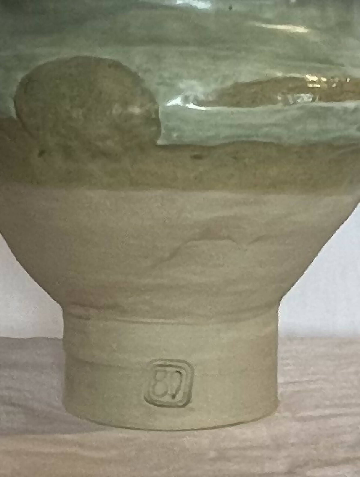 Vase en grès émaillé vert, décor en relief et petit écusson au centre