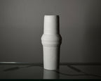 Vase en céramique clair, silhouette cylindrique et reliefs horizontaux, vue de profil