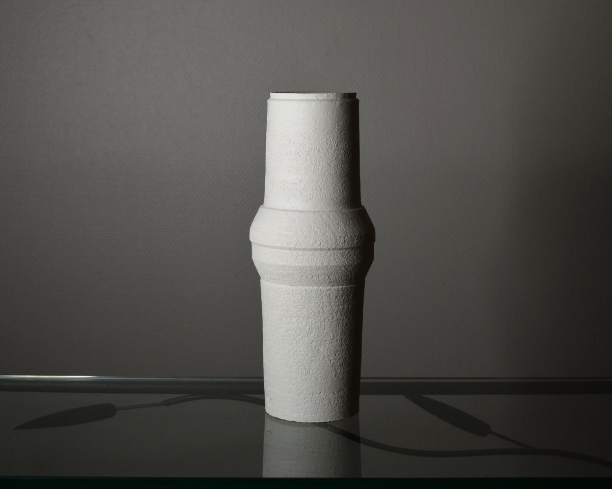Vase en céramique clair, silhouette cylindrique et reliefs horizontaux, vue de profil