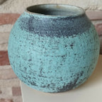 Vase en céramique bleu-vert texturé, vue rapprochée de la base