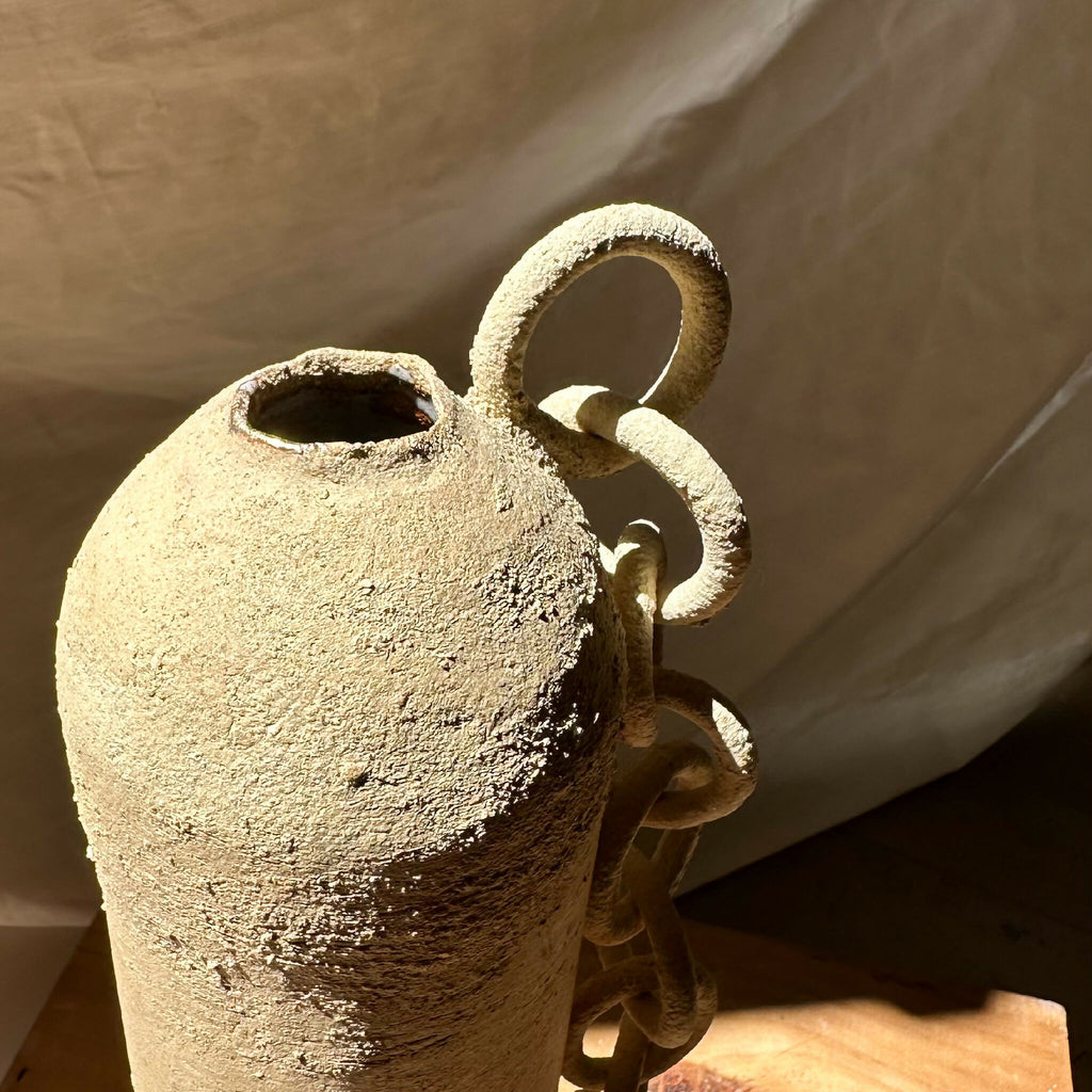 Vase en grès brut sculpté, ouvertures ovales et chaînons en relief