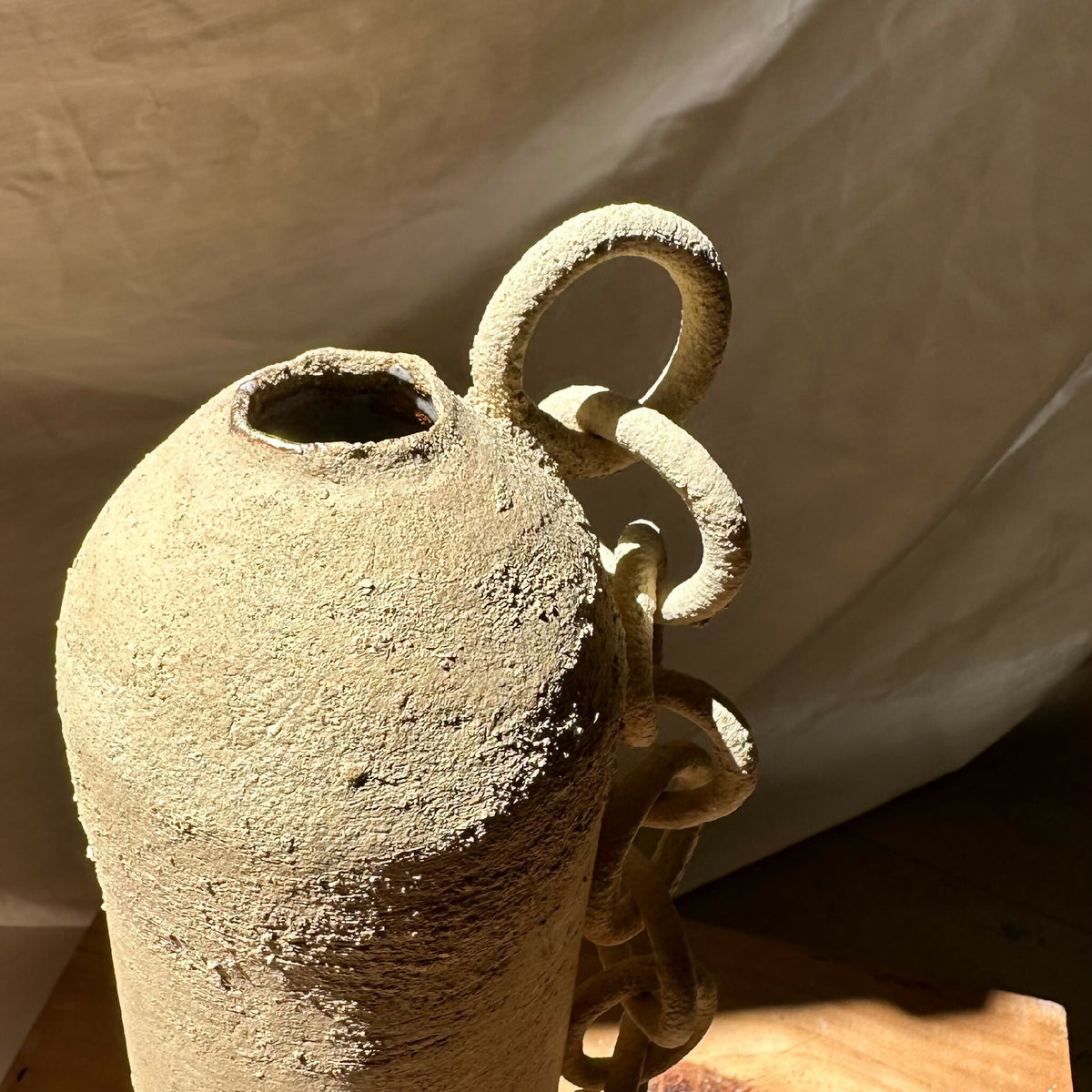 Vase en grès brut sculpté, ouvertures ovales et chaînons en relief