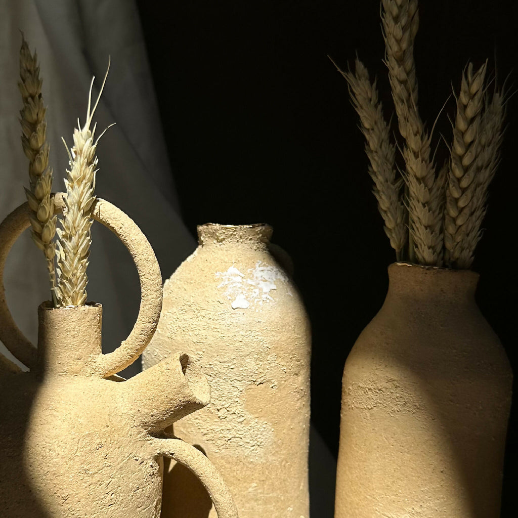 Vase en grès brut beige texturé, avec tiges de blé en bouquet.