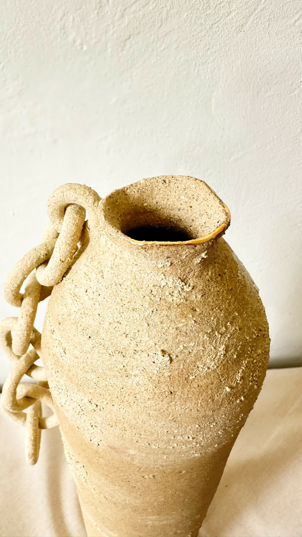 Vase en terre cuite brute à ouverture évasée, chaîne dorée sur le côté