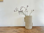 Vase cylindrique en grès beige piqueté, reliefs ronds sur le flanc.